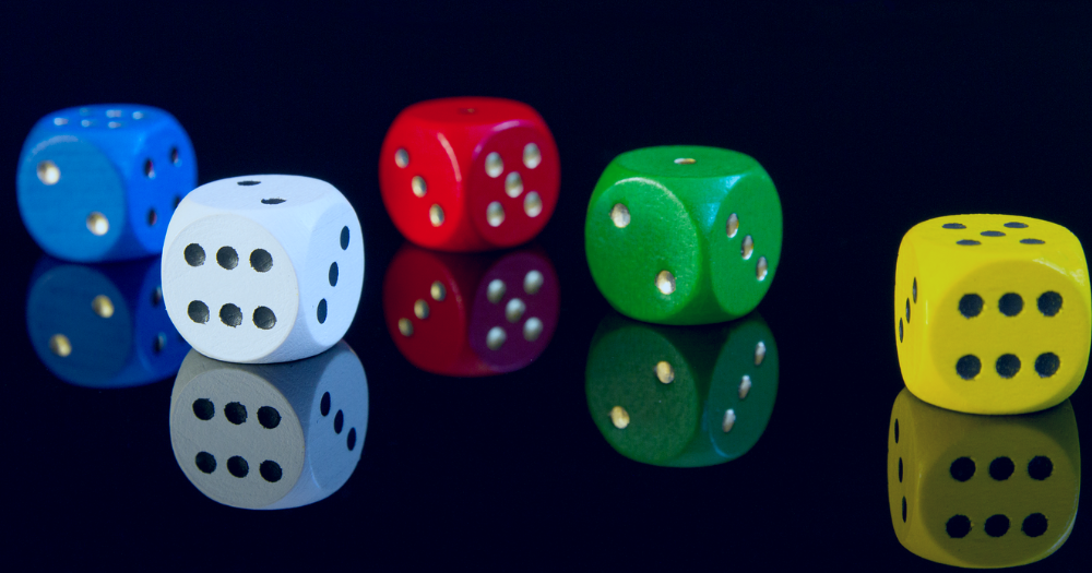 Pictured: five standard six-sided dice in different colours