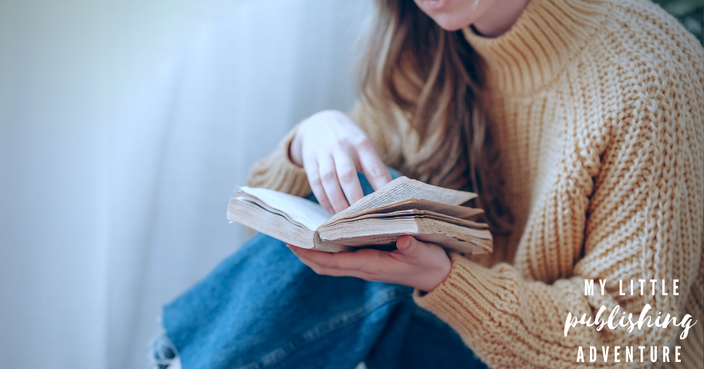 This blog is part of a series by mental health writer and Dear Blue Author, Saoirse Schad. Pictured: a girl wearing a wool jumper and jeans reads a book, her long hair falling over her shoulder.